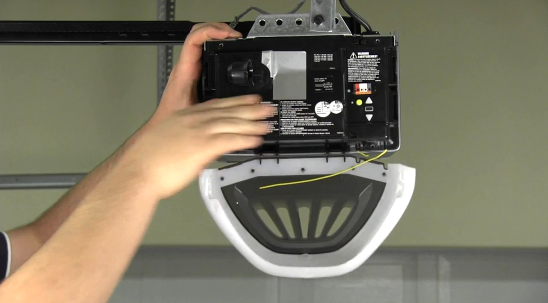 Technician repairing a garage door opener with tools and parts on a workbench to demonstrate professional garage door opener repair services.