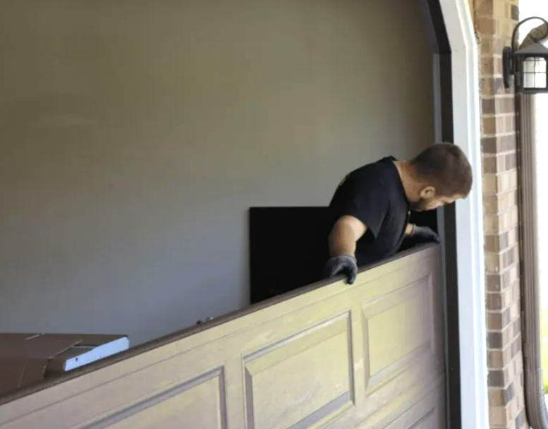 Technician performing garage door panel repair in Gahanna, Ohio.