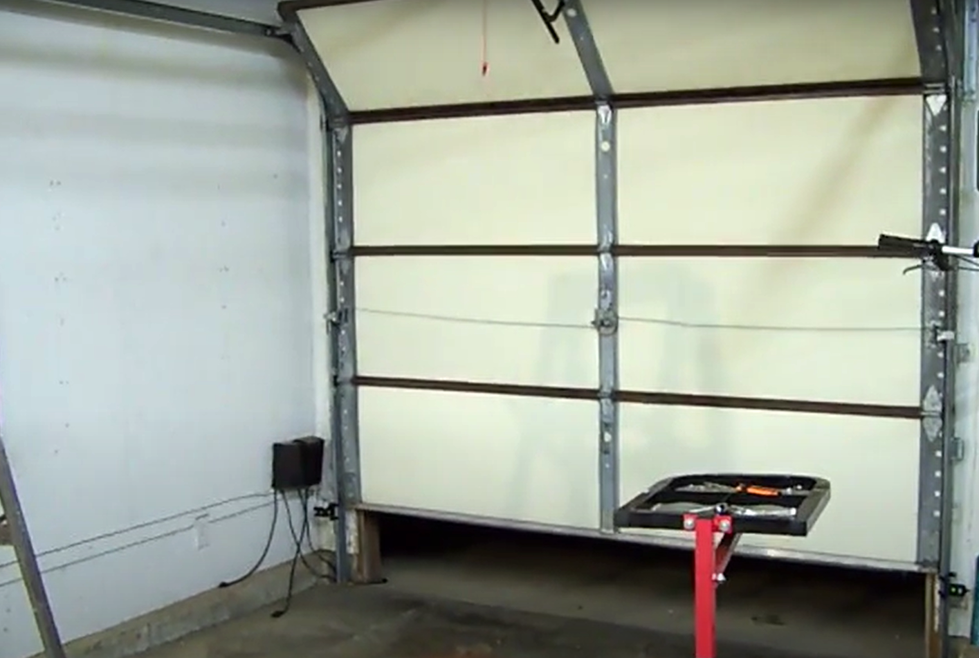 Overhead view of a garage door being repaired by a technician, highlighting the before-and-after results of a professional overhead garage door repair in Gahanna, Ohio