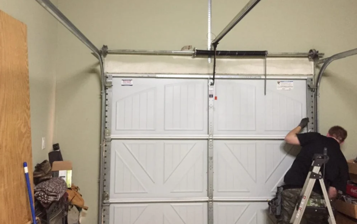 A technician installing a new garage door on a residential home in Gahanna, Ohio, as part of a garage door replacement service.