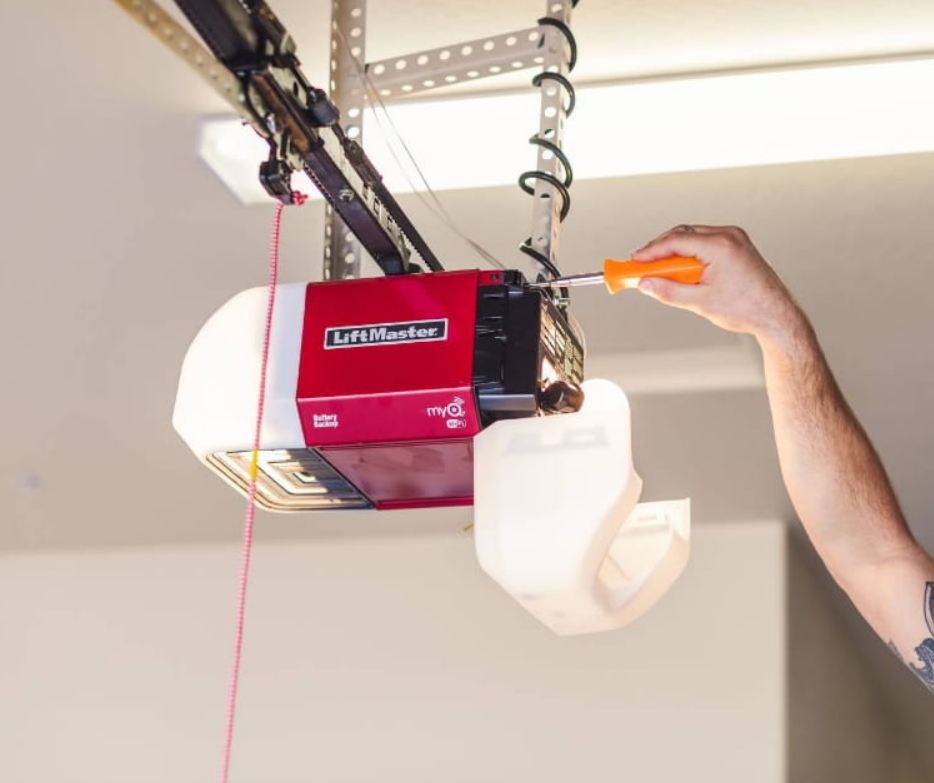 A technician performing garage door opener installation on a residential garage in Gahanna, Ohio, with tools and equipment visible.