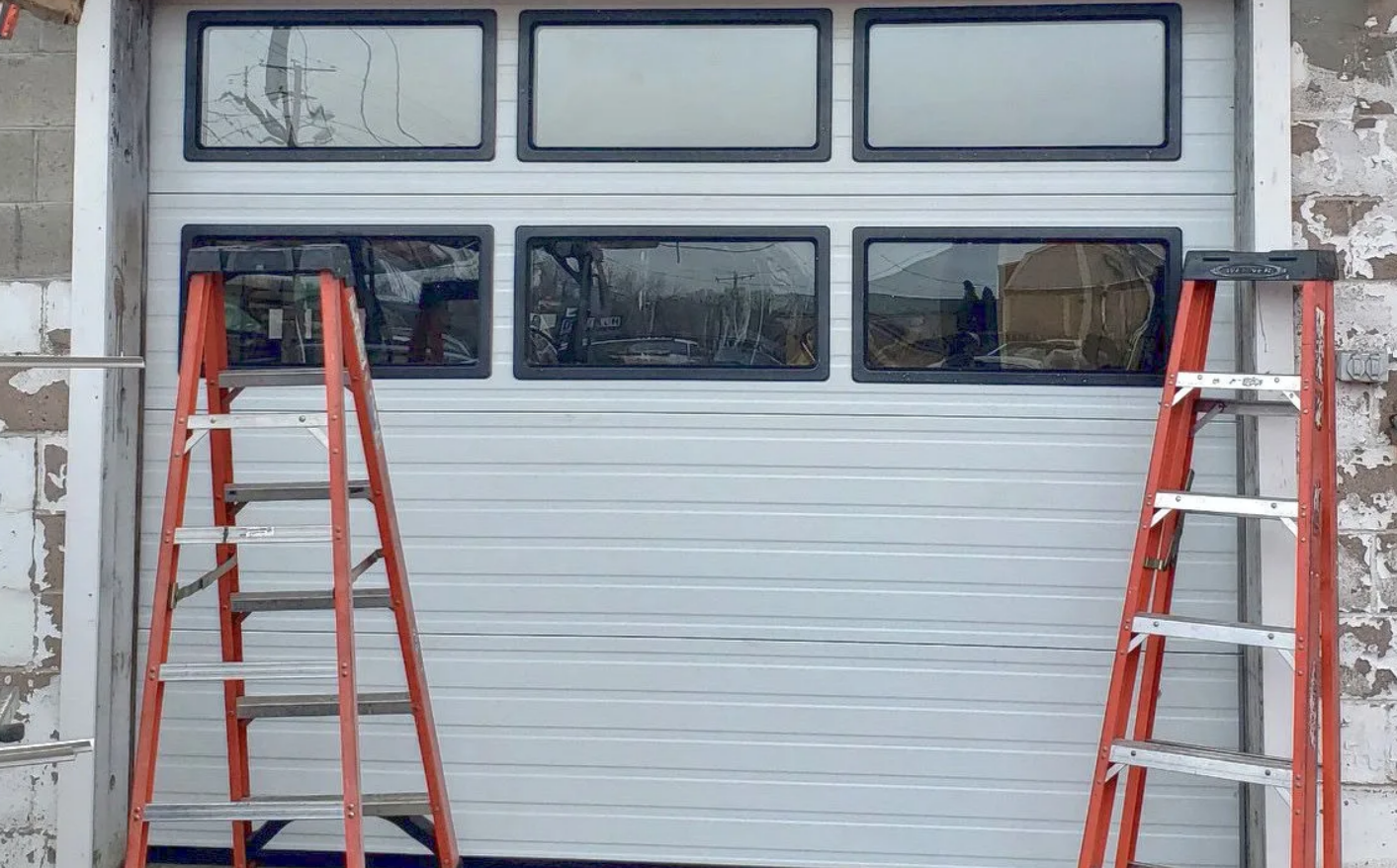 A professional technician performing garage door installation on a residential garage in Gahanna, Ohio, showcasing modern tools and high-quality materials.