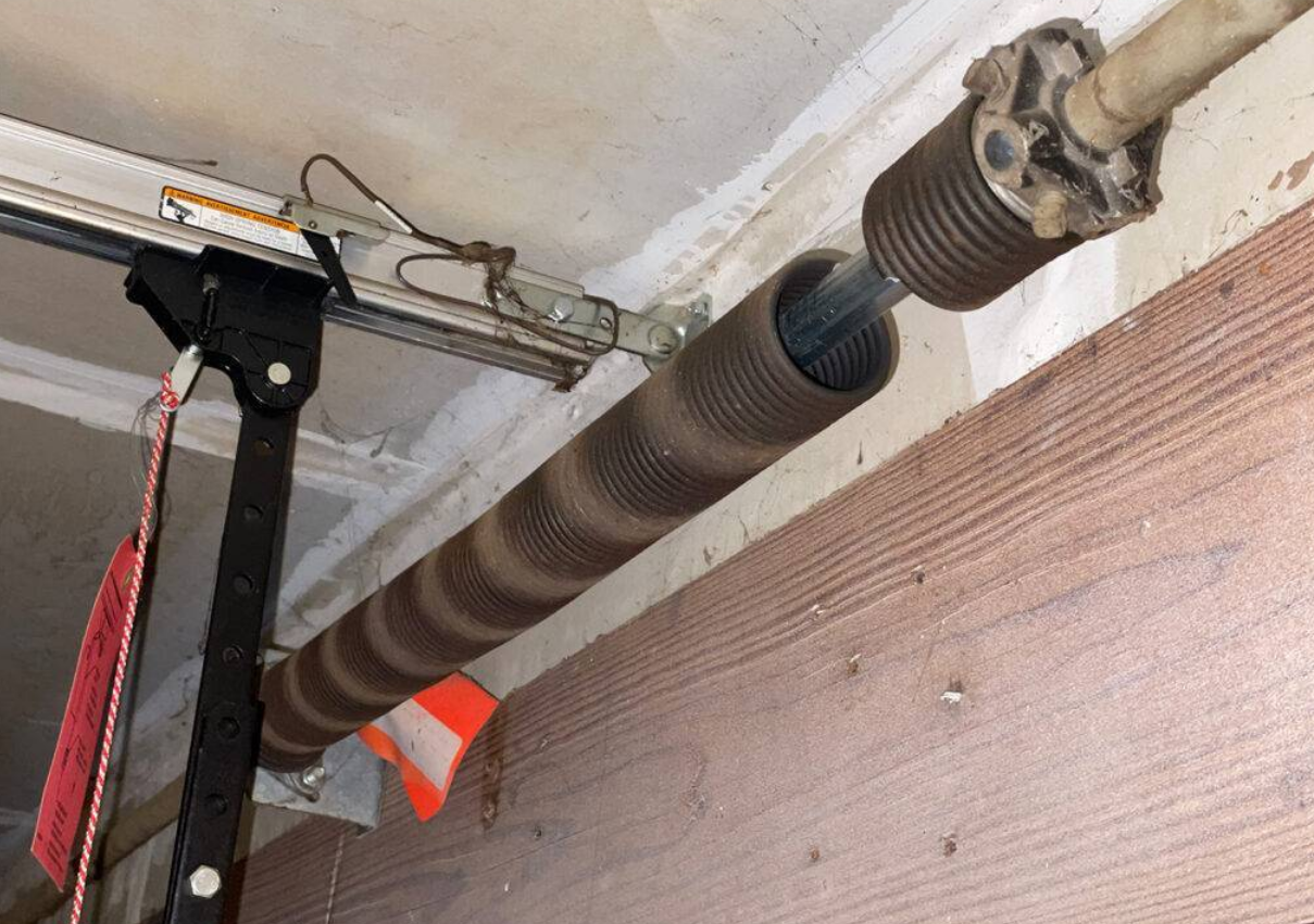 A technician performing garage door spring repair on a residential garage door in Gahanna, Ohio, ensuring proper function and safety.