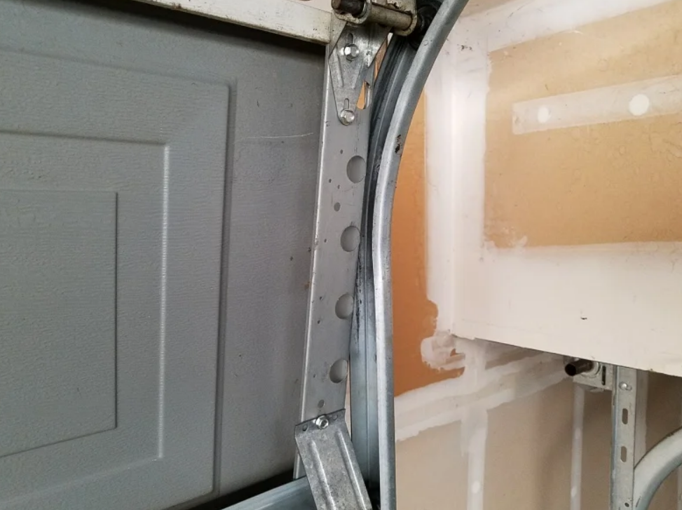A technician performing garage door track repair on a residential garage in Gahanna, Ohio, ensuring proper alignment and smooth operation.
