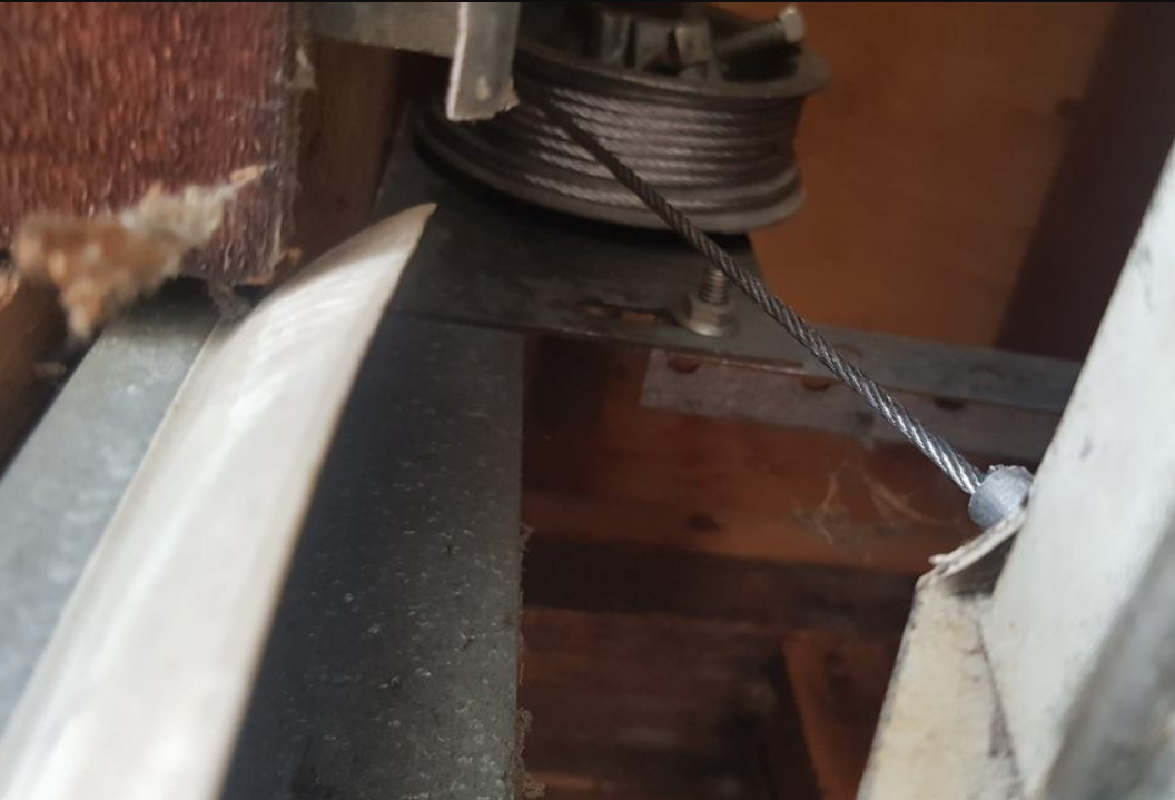 A technician performing garage door cable repair on a residential garage in Gahanna, Ohio, using professional tools and safety equipment.